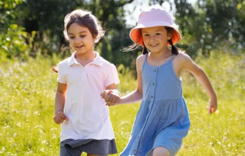 Two happy children run through a field