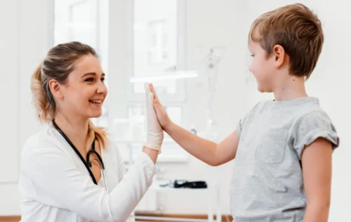 A young boy high fives a Doctor