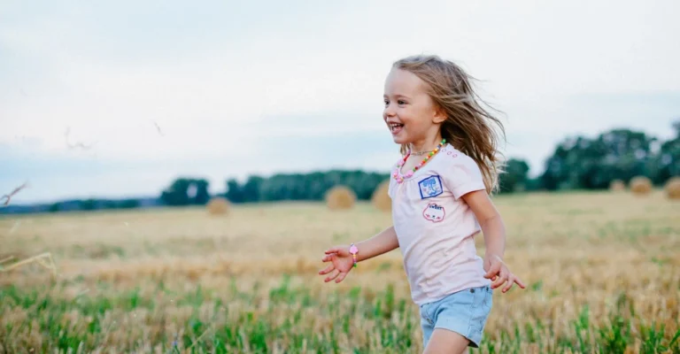 A young girl runs through a field